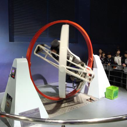 在中國科學技術館中，學員乘坐模擬器體驗太空人訓練。