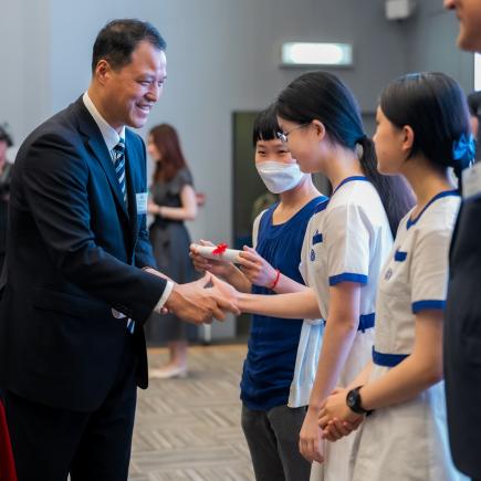 中央人民政府駐香港特別行政區聯絡辦公室青年工作部二級巡視員張國來先生與得奬學生握手，祝賀他們獲獎。