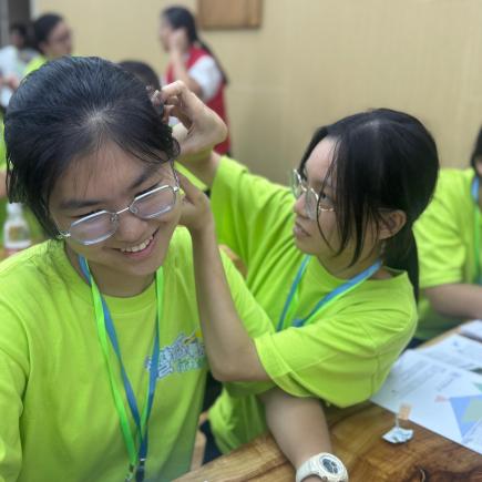 學生於廣東中醫藥博物館體驗貼耳穴，認識不同的耳穴穴位與身體不同部位的對照關係。