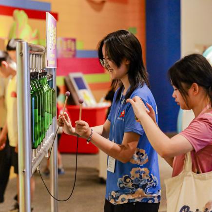 学生在澳门科学馆体验馆内设施，了解科学原理。