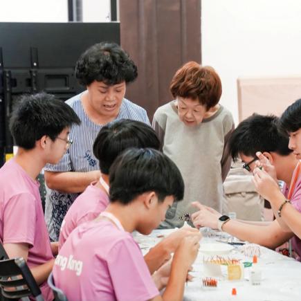 学生正专心跟从非遗小火龙工作坊导师的指导，制作自己的作品。