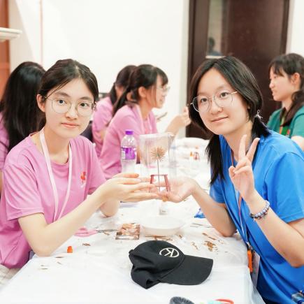 学生与合作而成的作品合影，记录见证友谊的瞬间。