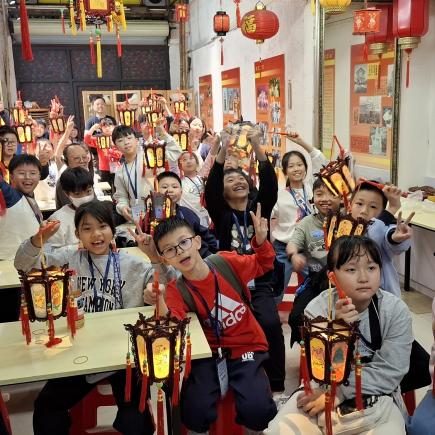 學生於親身體驗宮燈製作技藝後，一同提起宮燈的製成品，拍下大合照。