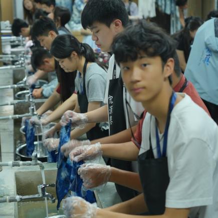 學生於烏鎮西柵景區體驗體驗藍印花布紮染，體會民間傳統工藝的匠心傳承