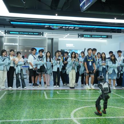 学生于文三数字生活街区接触不同类型的机器人，感受国家科技发展的成就