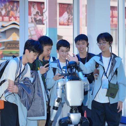 学生于文三数字生活街区接触不同类型的机器人，感受国家科技发展的成就
