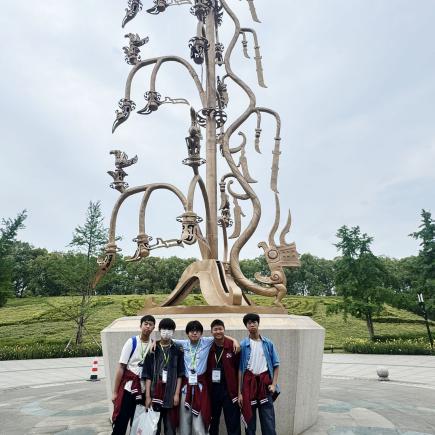 學生在三星堆園區與文物雕塑合照留念。