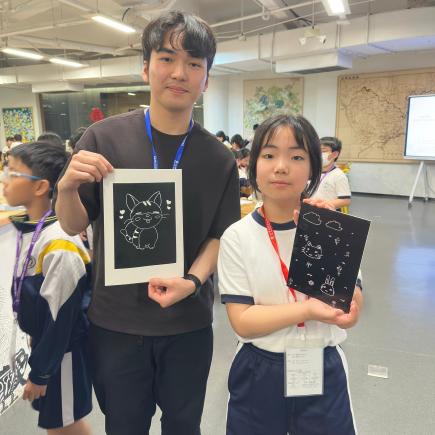 师生分别手持完成印刷的作品和用于创作的凹版。
