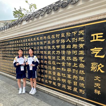 学生在文天祥廉政教育馆外刻有《正气歌》的照壁前留影。