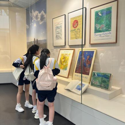 学生细心观赏版画作品，细味其构图与色彩运用的美感。